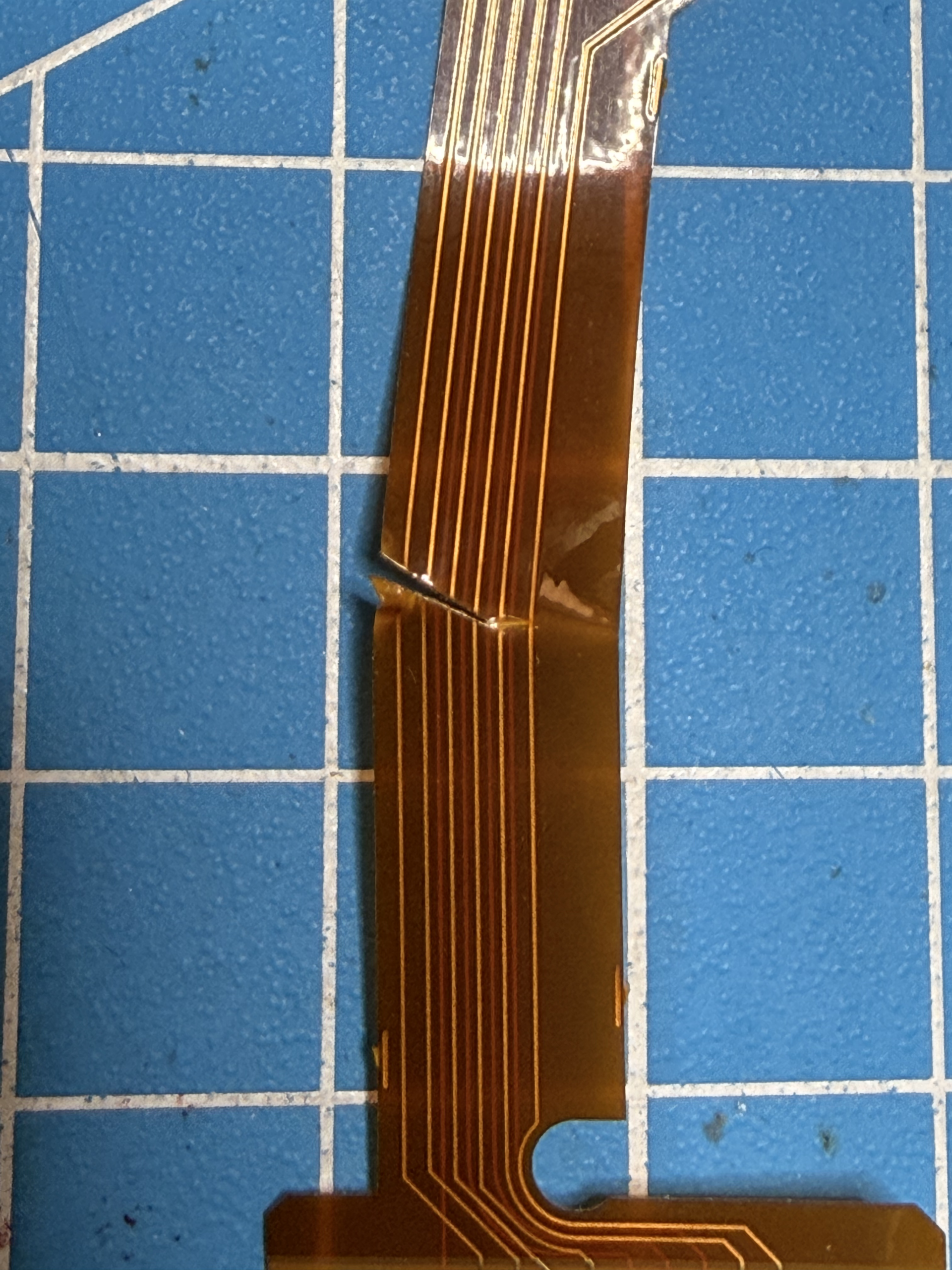 Otthoni kontroller okosítás (modding) során elszakított szalagkábel és tönkretett alaplap egy PS5 kontrollerben